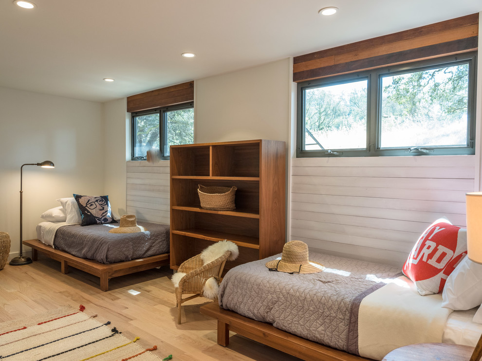 Cette photo montre une chambre d'amis rétro de taille moyenne avec un mur blanc, un sol en bois brun, aucune cheminée et un sol marron.