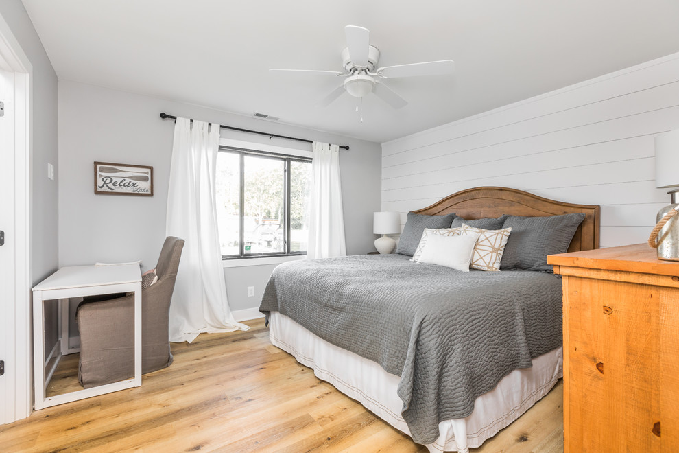 Ejemplo de dormitorio principal marinero con paredes grises y suelo de madera clara