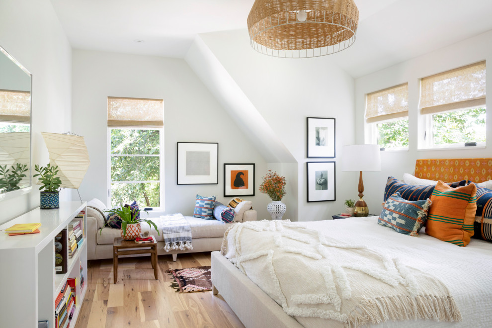 Imagen de dormitorio principal bohemio grande sin chimenea con paredes blancas, suelo de madera clara y suelo beige