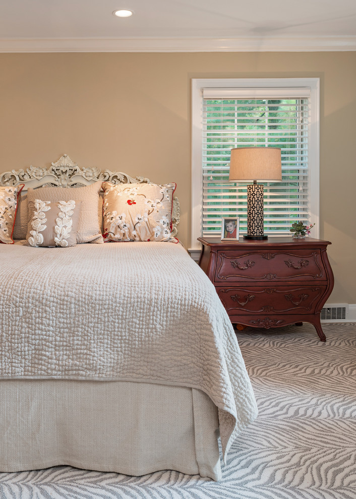 Large classic master bedroom in St Louis with beige walls and dark hardwood flooring.