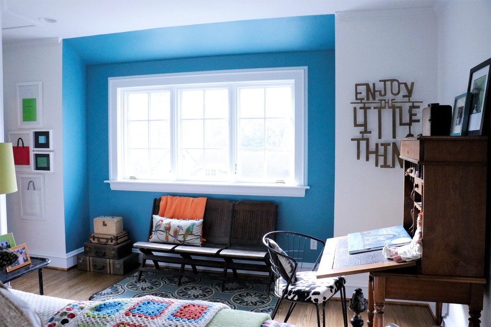 Idée de décoration pour une chambre d'amis tradition de taille moyenne avec un mur bleu et un sol en bois brun.