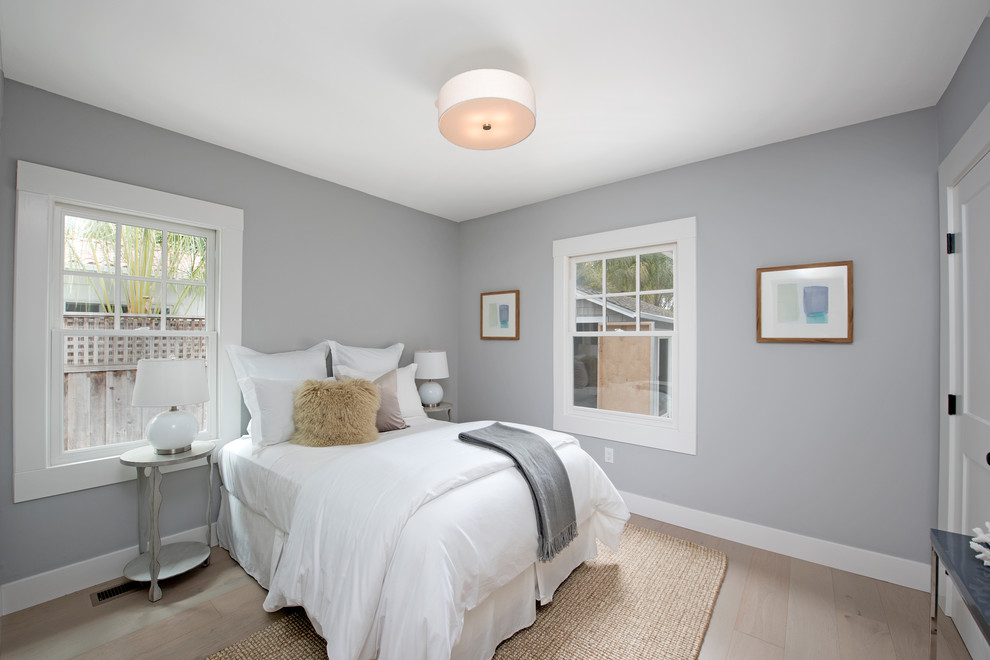 Foto de habitación de invitados minimalista pequeña sin chimenea con paredes grises, suelo de madera clara y suelo beige