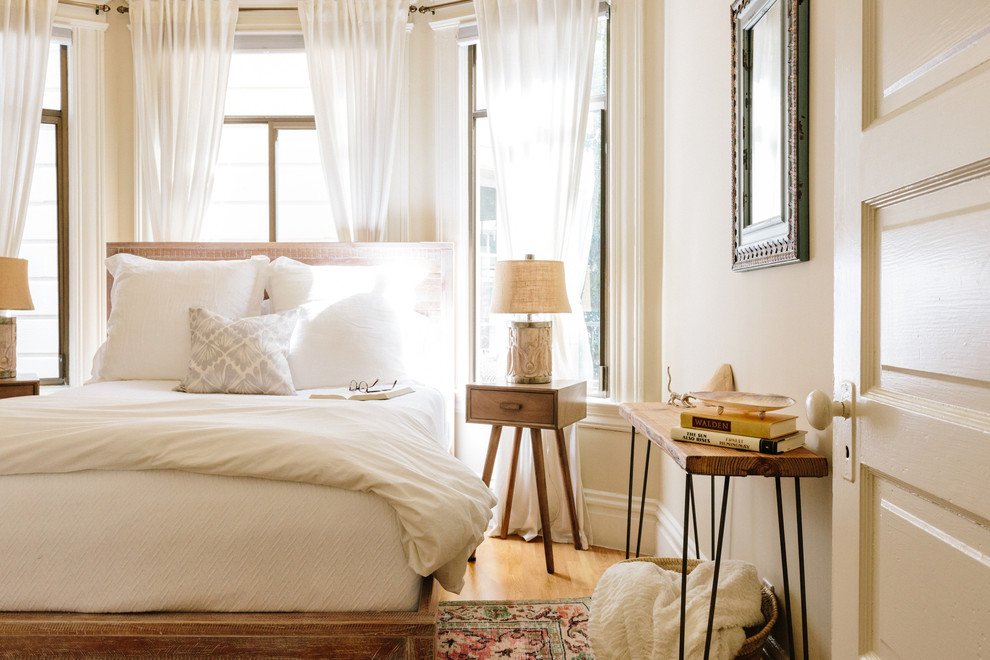 Cette photo montre une petite chambre parentale tendance avec un mur beige, parquet clair et un sol beige.