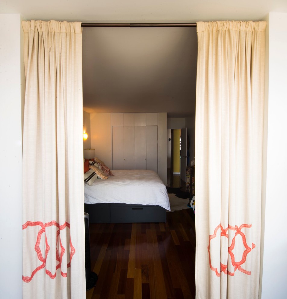 Ejemplo de dormitorio principal bohemio pequeño sin chimenea con paredes blancas y suelo de madera en tonos medios