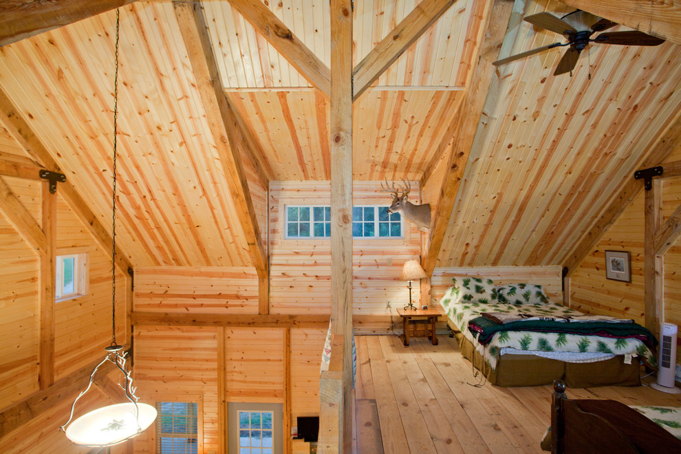 Imagen de dormitorio tipo loft rural con suelo de madera clara