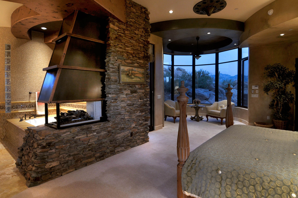 Imagen de dormitorio de estilo americano con chimenea de doble cara