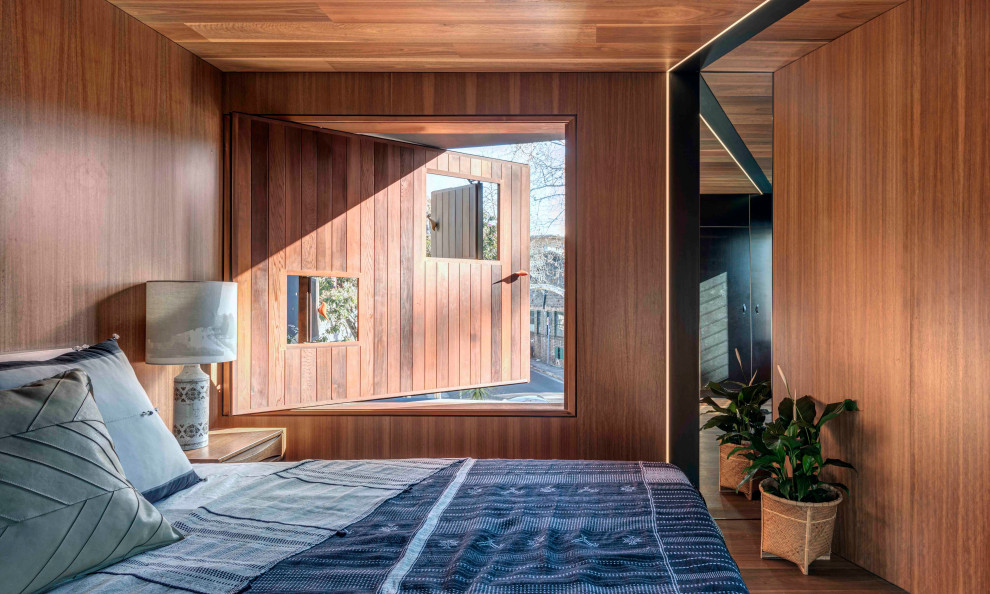 Immagine di una camera da letto industriale con soffitto in legno e pareti in legno