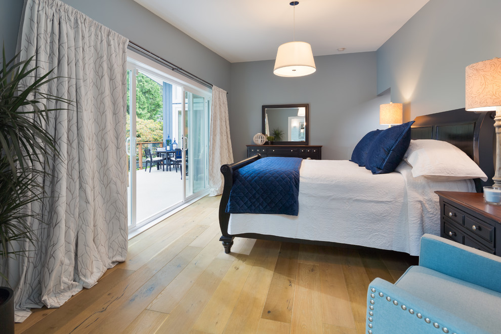 Medium sized modern master bedroom with blue walls, laminate floors and brown floors.