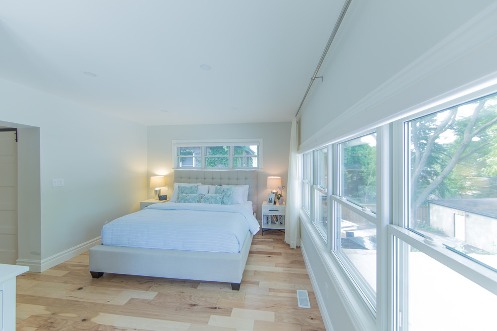 Mittelgroßes Modernes Hauptschlafzimmer mit beiger Wandfarbe und hellem Holzboden in Toronto