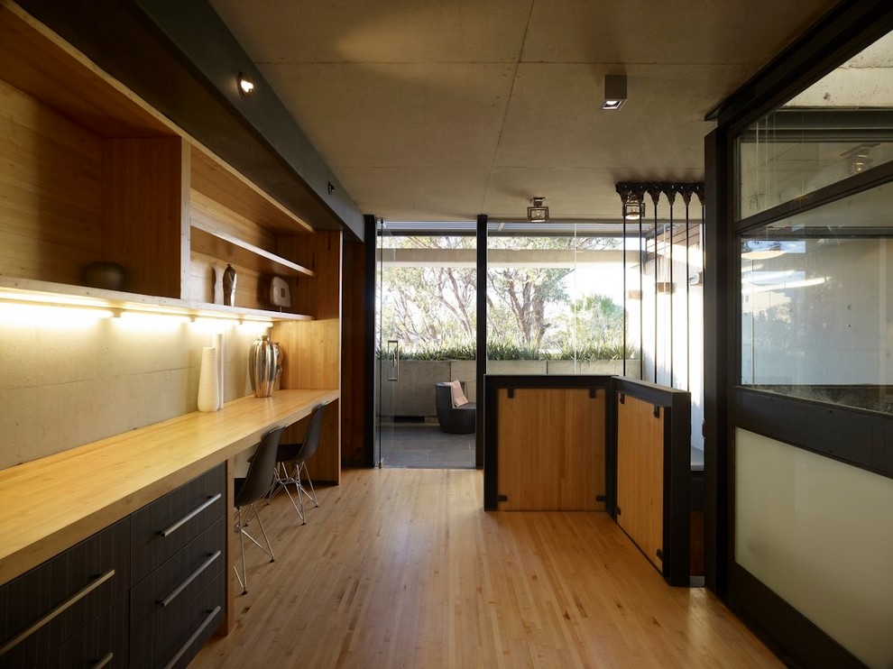 Idée de décoration pour une chambre mansardée ou avec mezzanine urbaine de taille moyenne avec parquet clair et un sol beige.