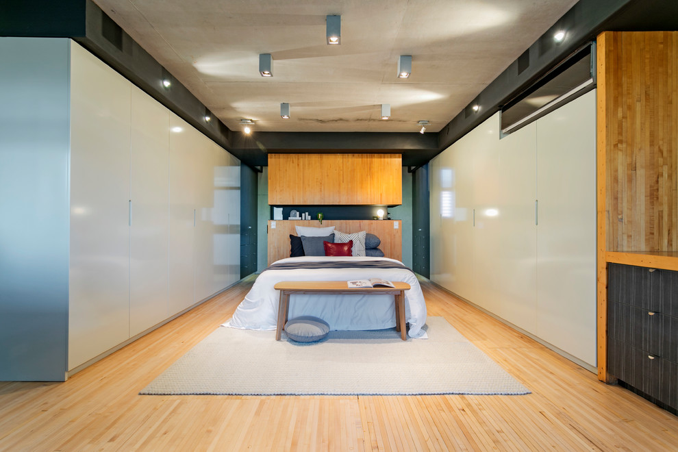Idée de décoration pour une chambre parentale urbaine avec parquet en bambou et un sol beige.
