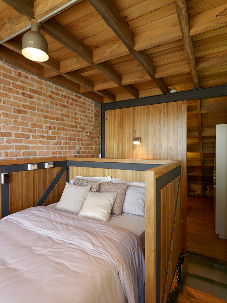 Imagen de dormitorio contemporáneo pequeño sin chimenea con suelo de madera en tonos medios