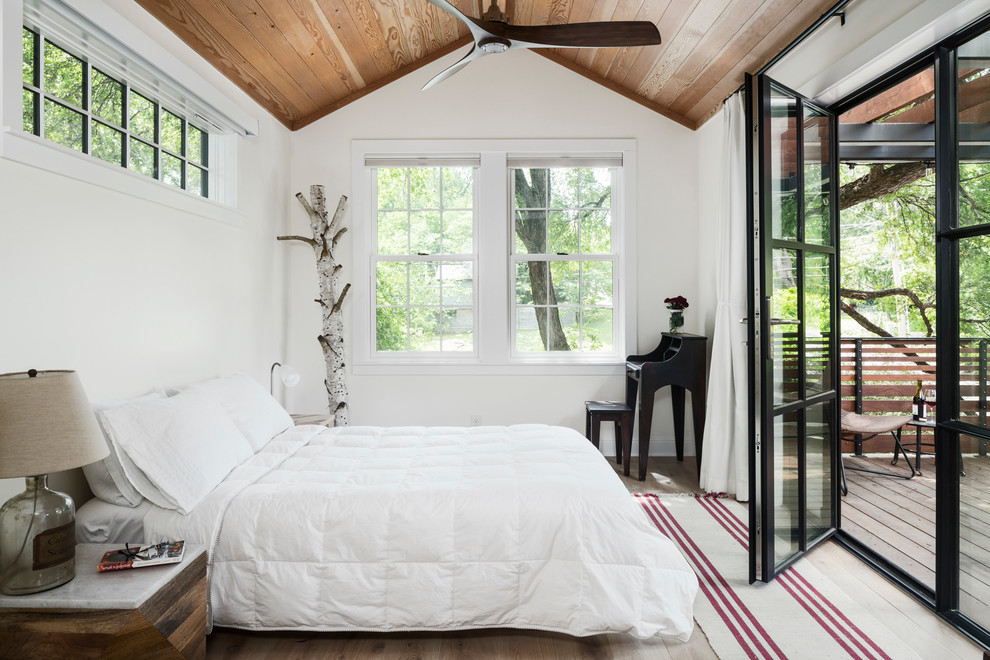 Photo of a rural master bedroom in Austin with white walls, light hardwood flooring and no fireplace.