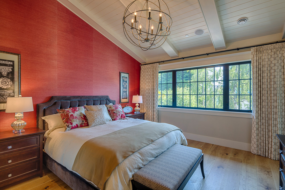 Ejemplo de dormitorio principal de estilo americano grande sin chimenea con paredes rojas y suelo de madera clara