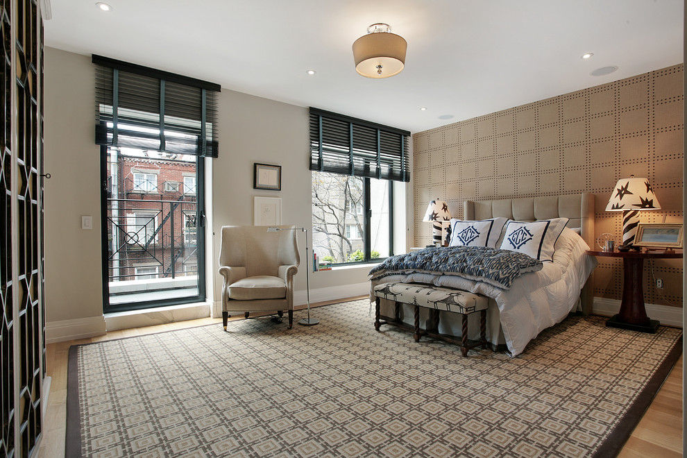 Ejemplo de habitación de invitados actual grande con paredes beige, suelo de madera clara y suelo beige
