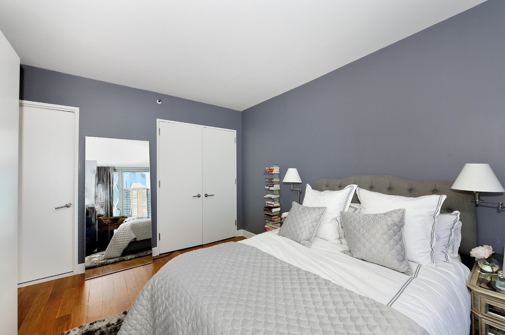 Example of a mid-sized trendy master medium tone wood floor bedroom design in New York with gray walls