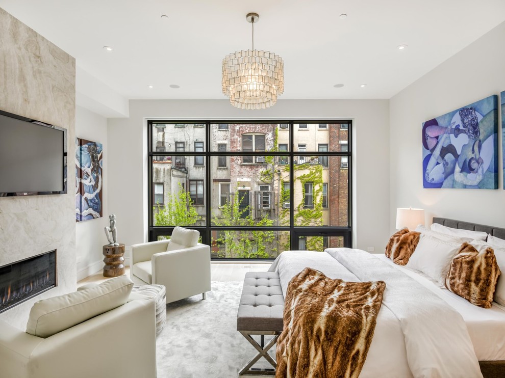 Großes Modernes Hauptschlafzimmer mit weißer Wandfarbe, Gaskamin, Teppichboden, gefliester Kaminumrandung und grauem Boden in New York