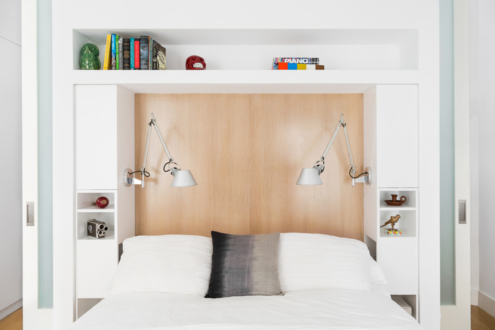 Imagen de dormitorio principal contemporáneo de tamaño medio sin chimenea con paredes blancas, suelo de madera clara y suelo blanco