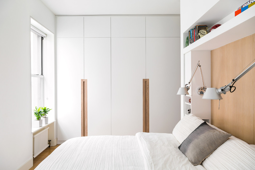 Mittelgroßes Modernes Hauptschlafzimmer ohne Kamin mit weißer Wandfarbe, hellem Holzboden und weißem Boden in New York