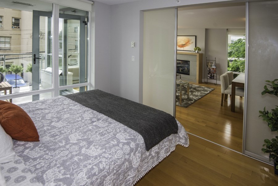バンクーバーにある小さなトランジショナルスタイルのおしゃれな主寝室 (グレーの壁、淡色無垢フローリング)