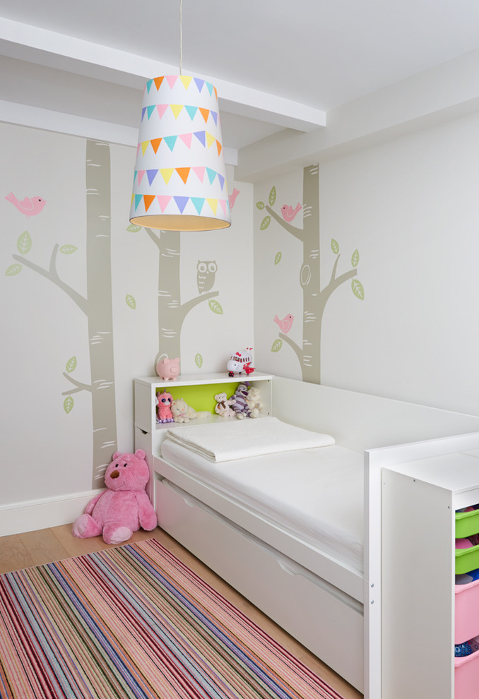 Diseño de habitación de invitados contemporánea pequeña con paredes blancas, suelo de madera clara y suelo beige