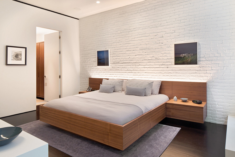 Imagen de dormitorio principal contemporáneo con paredes blancas y suelo de madera oscura