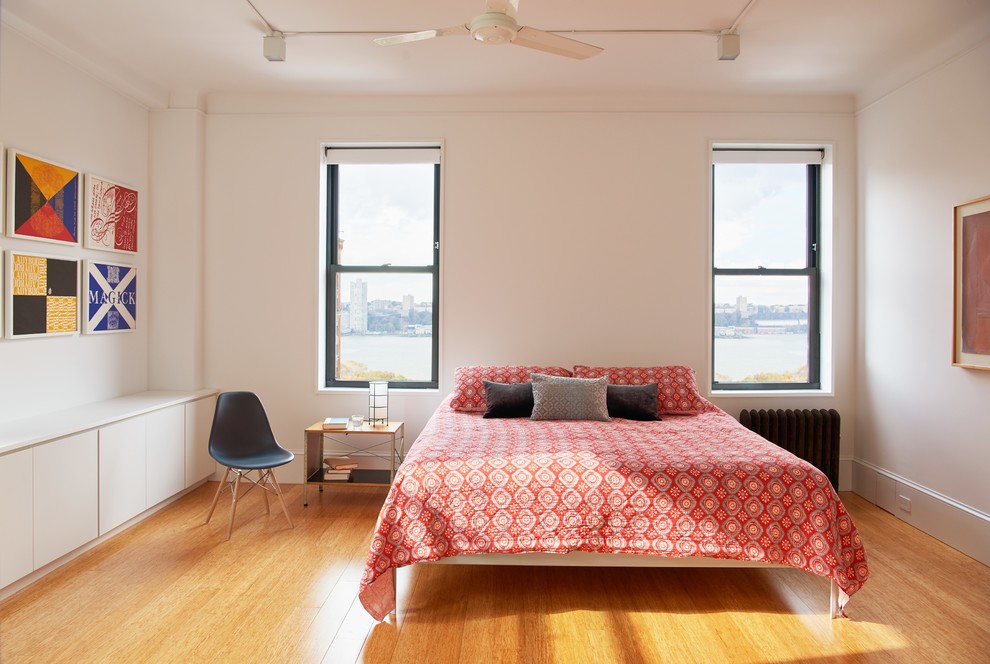 Idéer för ett modernt sovrum, med brunt golv, vita väggar och mellanmörkt trägolv