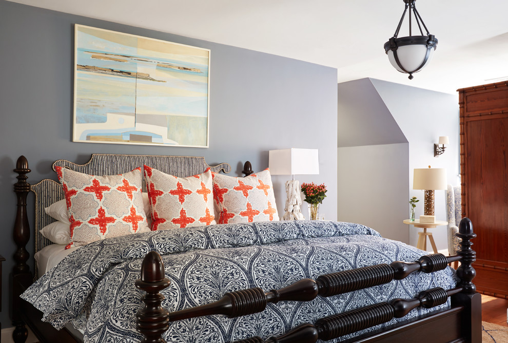 Example of a large beach style master medium tone wood floor and brown floor bedroom design in Boston with blue walls