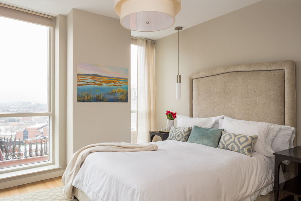 Diseño de dormitorio actual con paredes beige, suelo de madera clara y suelo beige