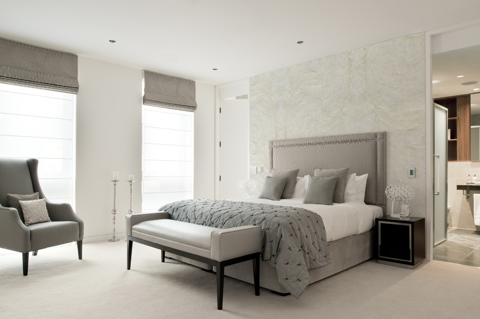 На фото: хозяйская, серо-белая спальня в современном стиле с белыми стенами, ковровым покрытием и серым полом с