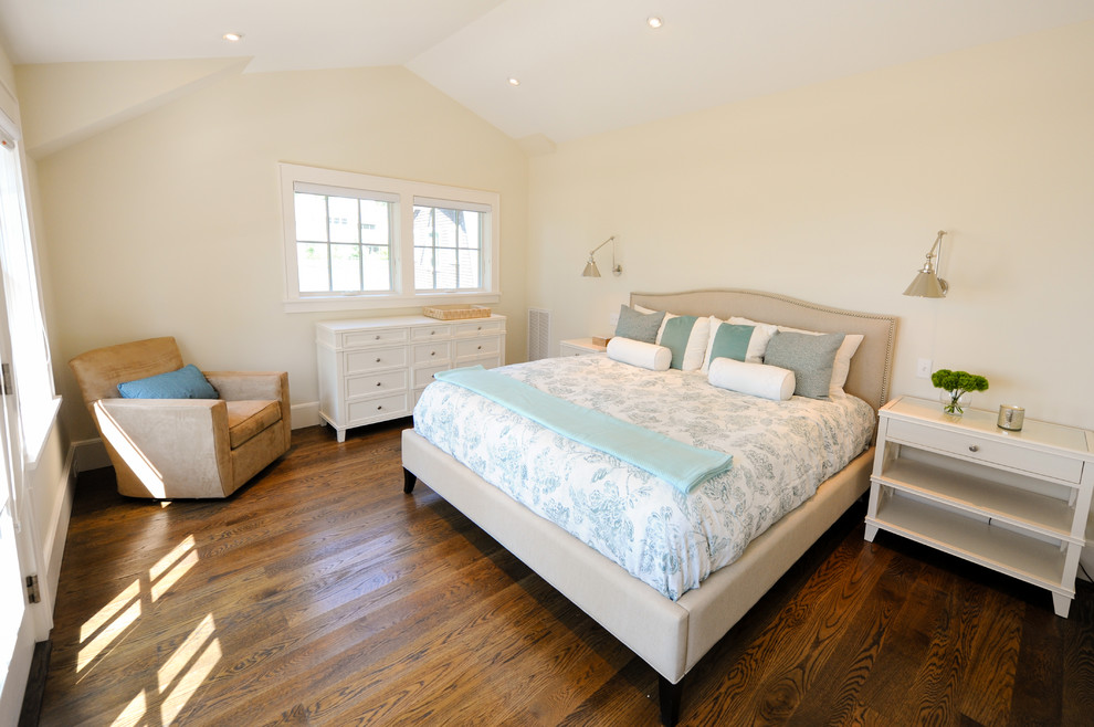 Immagine di una camera matrimoniale stile marino con pareti beige, pavimento in legno massello medio, nessun camino e pavimento marrone
