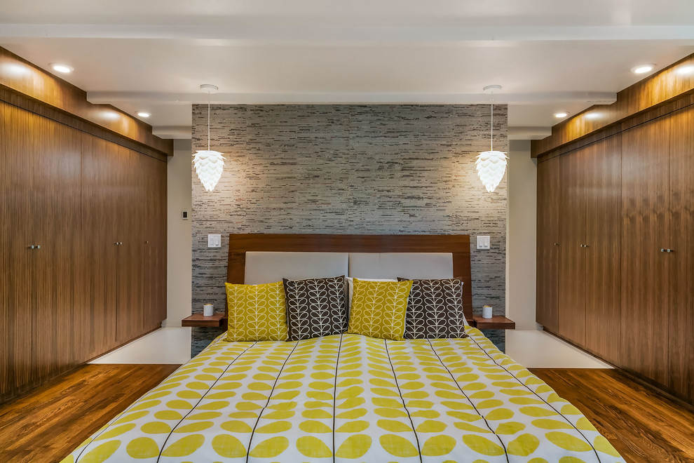 Großes Retro Hauptschlafzimmer mit bunten Wänden und braunem Holzboden in Sonstige