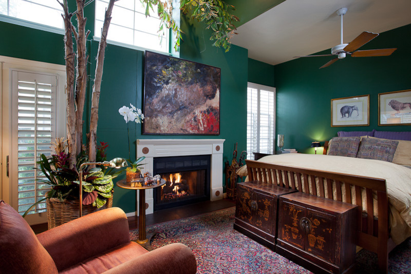 Idée de décoration pour une grande chambre parentale bohème avec un mur vert, parquet foncé, une cheminée standard et un manteau de cheminée en bois.