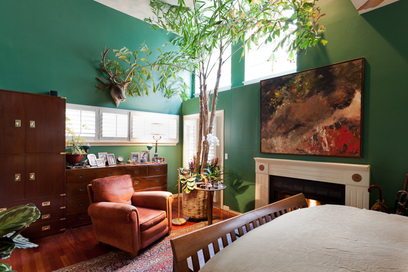 ロサンゼルスにある広いエクレクティックスタイルのおしゃれな主寝室 (緑の壁、濃色無垢フローリング、標準型暖炉、木材の暖炉まわり)