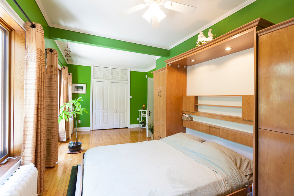 Design ideas for a bohemian bedroom in Montreal with green walls and medium hardwood flooring.