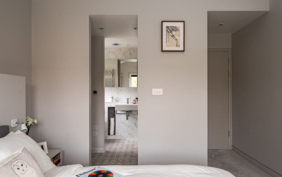 Diseño de dormitorio principal actual de tamaño medio sin chimenea con paredes beige, moqueta y suelo gris