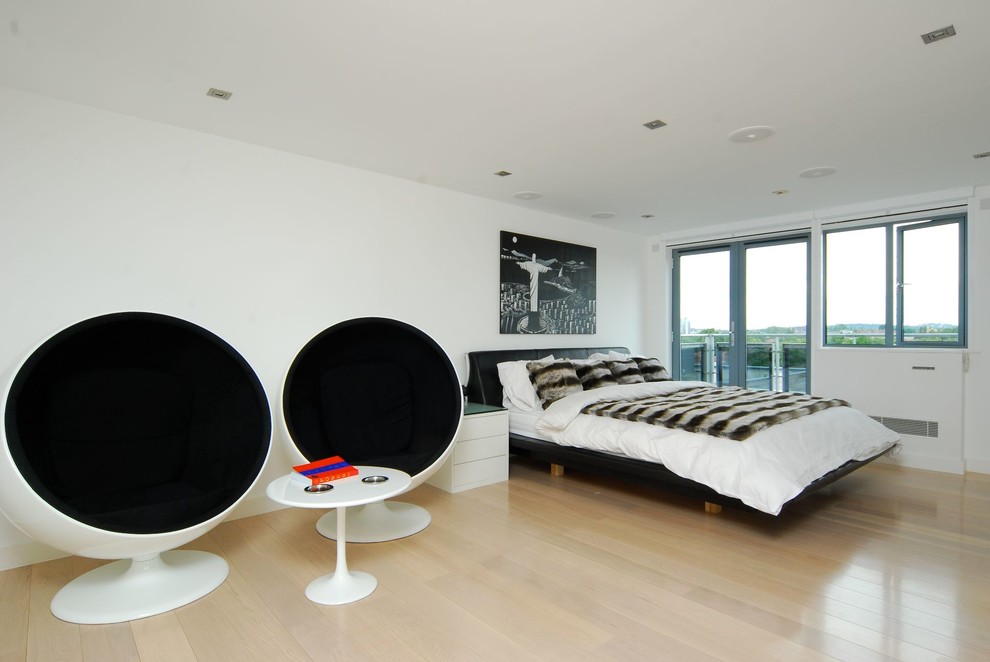 Exempel på ett modernt sovrum, med vita väggar och ljust trägolv