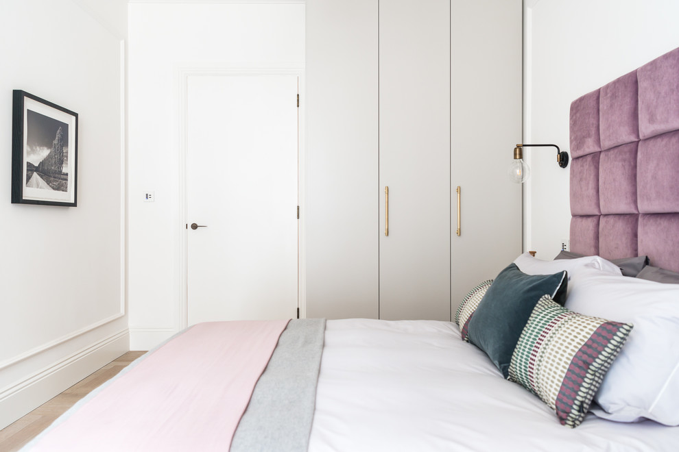 Exempel på ett klassiskt sovrum, med vita väggar, ljust trägolv och beiget golv