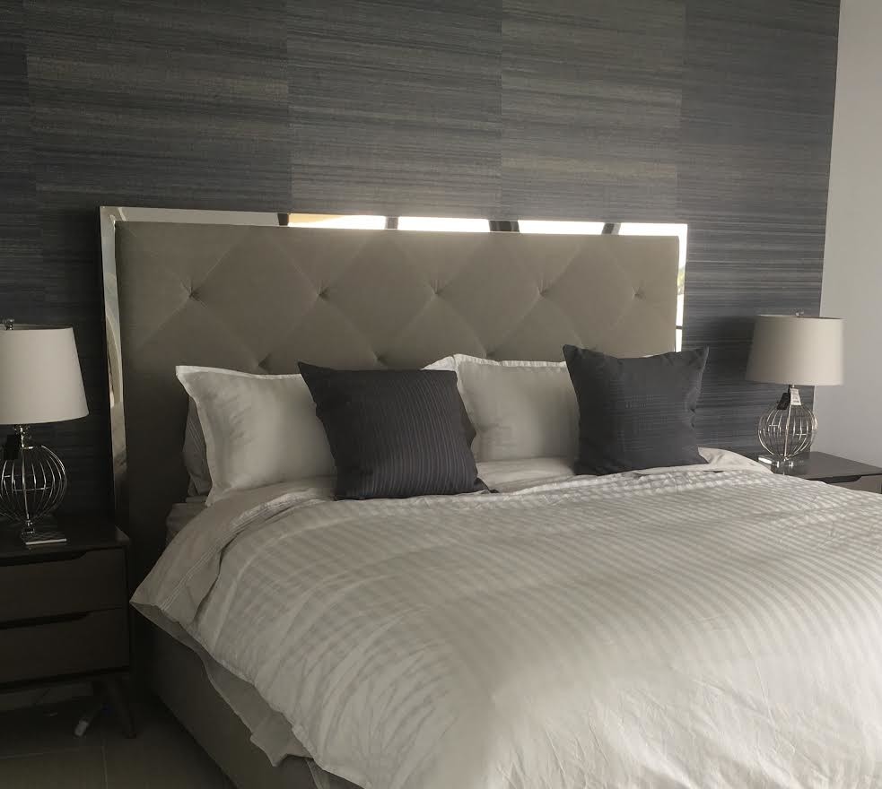 Large contemporary master bedroom in New York with grey walls and feature lighting.