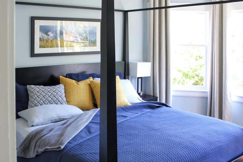 Idée de décoration pour une petite chambre parentale tradition avec un mur bleu et parquet foncé.