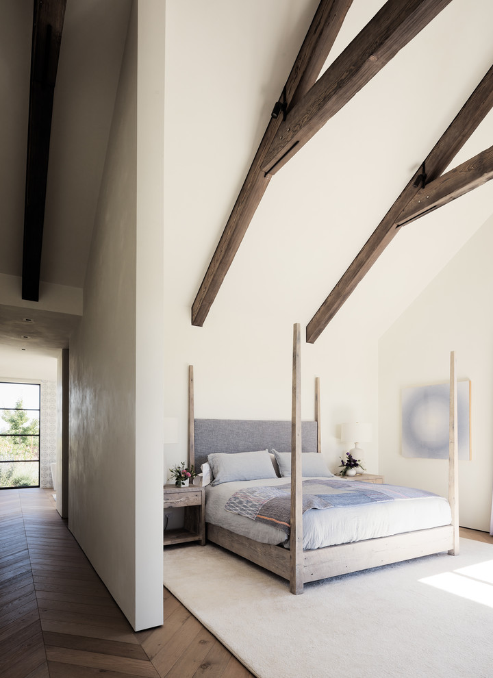 Ispirazione per una grande camera da letto country con pareti bianche, pavimento in legno massello medio e pavimento marrone