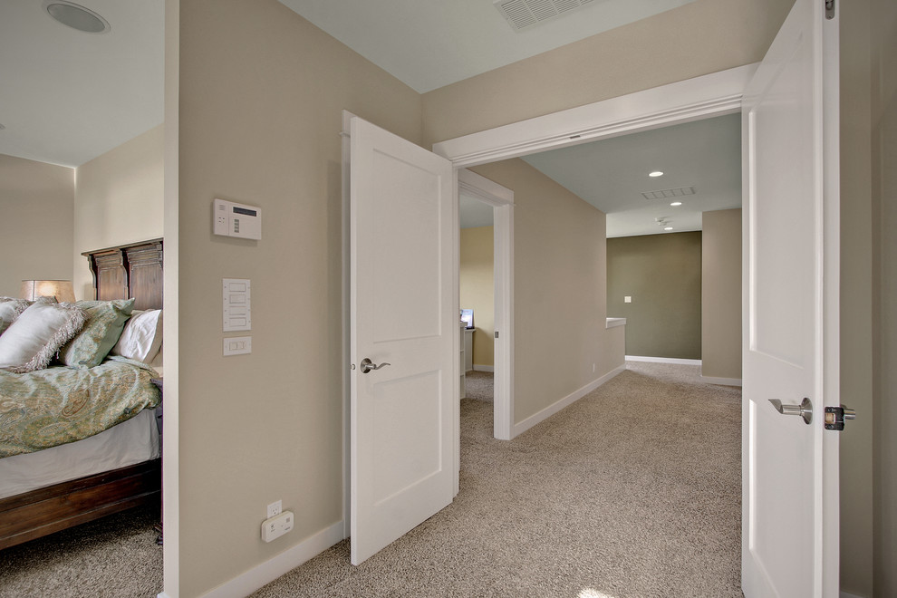 Ejemplo de dormitorio principal de estilo americano grande con paredes beige, moqueta, chimenea de esquina y marco de chimenea de baldosas y/o azulejos