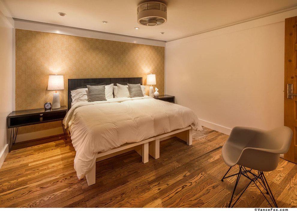 Modelo de dormitorio principal clásico renovado pequeño sin chimenea con paredes blancas y suelo de madera en tonos medios