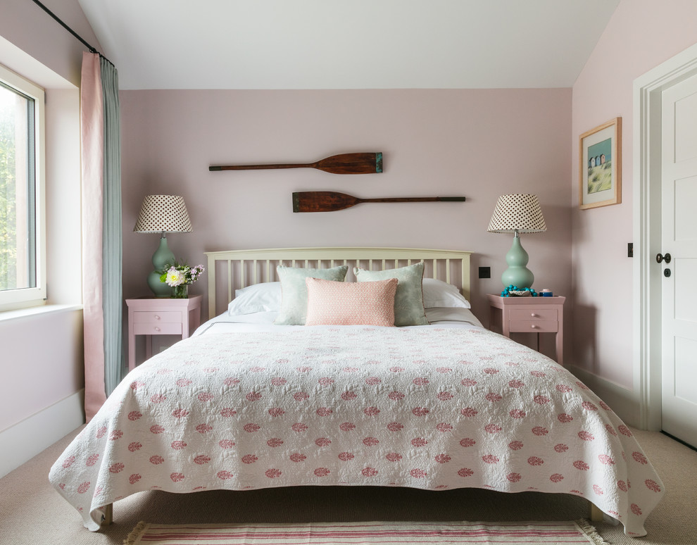 Imagen de habitación de invitados costera de tamaño medio sin chimenea con paredes rosas, moqueta y suelo beige
