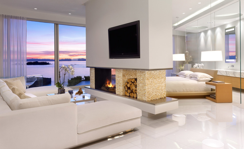 Bedroom - contemporary bedroom idea in Vancouver with white walls, a two-sided fireplace and a stone fireplace