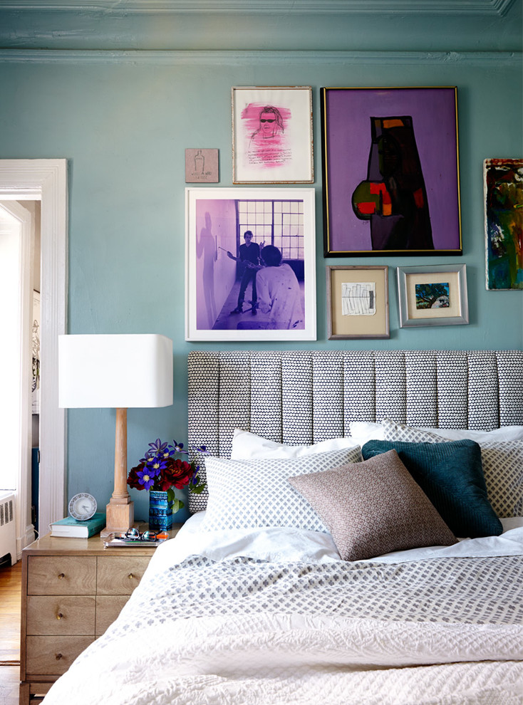 Design ideas for a small eclectic master bedroom in New York with blue walls and medium hardwood flooring.