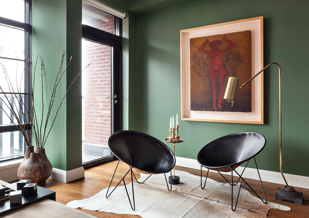 Idée de décoration pour une grande chambre parentale design avec un mur vert et un sol en bois brun.