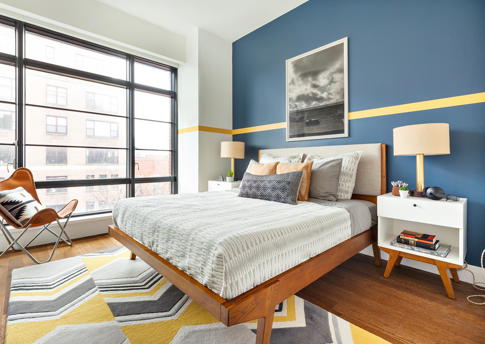 Ejemplo de habitación de invitados actual de tamaño medio sin chimenea con paredes multicolor y suelo de madera en tonos medios