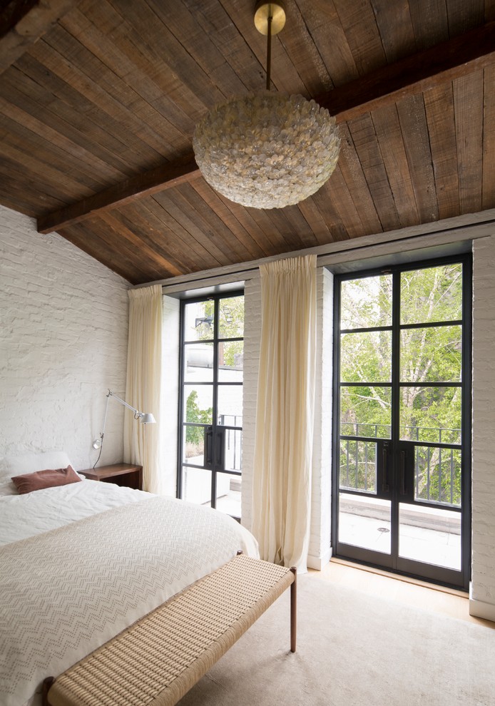 Diseño de dormitorio principal contemporáneo con paredes blancas, suelo de madera clara, todas las chimeneas y marco de chimenea de metal