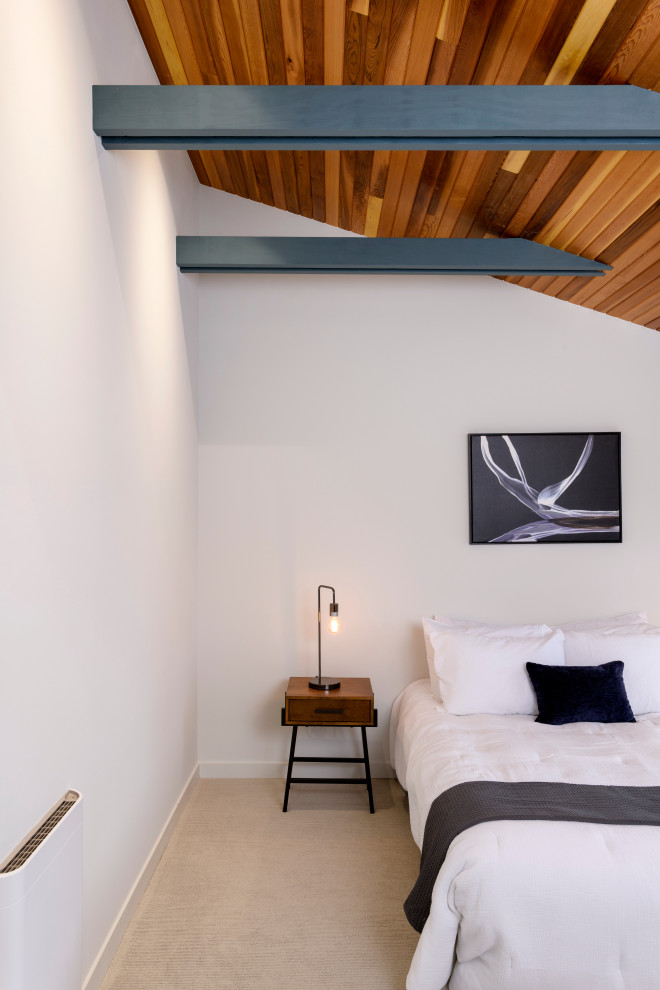 Esempio di una camera degli ospiti minimalista di medie dimensioni con pareti bianche, moquette, pavimento beige e travi a vista